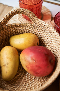 Handwoven rattan basket with mangoes