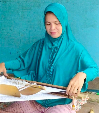 woman weaving on a wooden loom